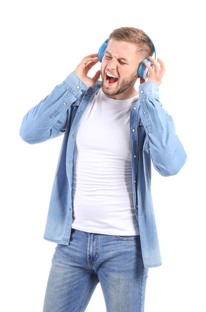 Handsome young man listening to music on white background - Photo, image