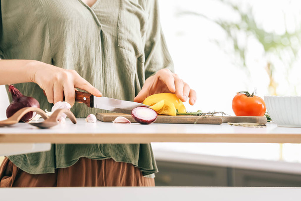Woman making healthy vegetable salad in kitchen, closeup - Photo, Image