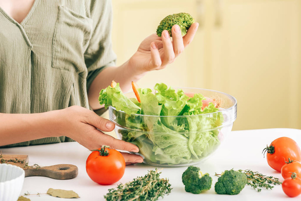Vrouw het maken van gezonde groente salade in de keuken, close-up - Foto, afbeelding