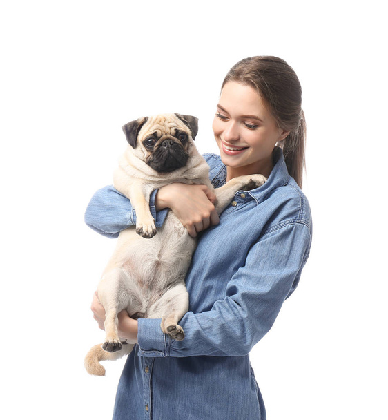 Beautiful young woman with cute pug dog on white background - Фото, изображение