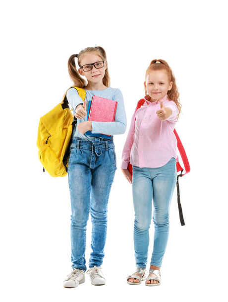 Симпатичные маленькие школьницы показывают большой палец вверх на белом фоне
 - Фото, изображение