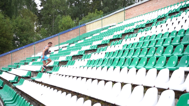 Hombre corriendo escaleras del estadio entre asientos en cámara lenta
 - Metraje, vídeo