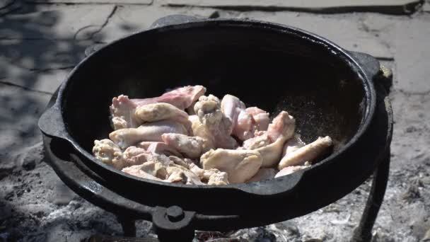 Kuře se smaží v kotli, nad otevřeným ohněm - Záběry, video