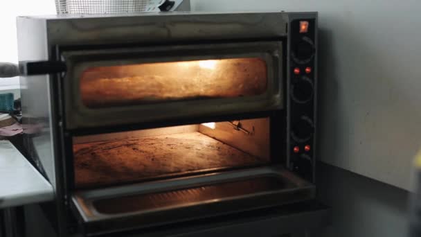 Elhelyezés a tésztát pizza bázis egy elektromos sütő - Felvétel, videó