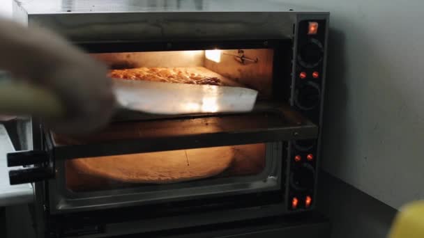 Βάζοντας μια βάση πίτσας σε έναν ηλεκτρικό φούρνο - Πλάνα, βίντεο