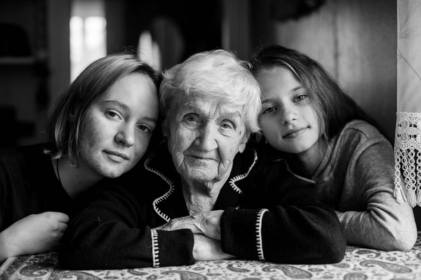 Oma posiert mit ihren beiden Enkelinnen. Schwarz-Weiß-Foto. - Foto, Bild