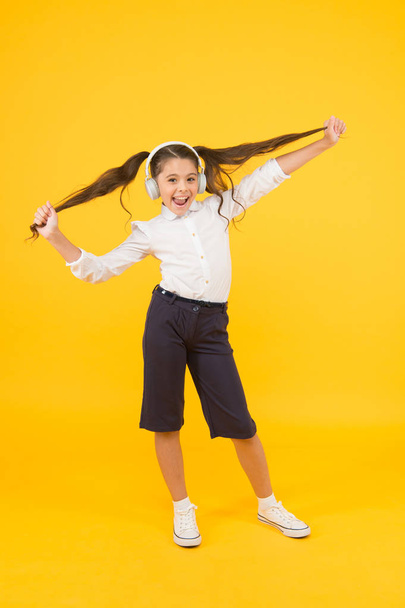 Sing song. Audio book. Education and fun concept. Online schooling. Listening lesson. Child enjoy music sound. Audio schooling. Home schooling. Small girl pupil headphones. Child happy listen music - 写真・画像