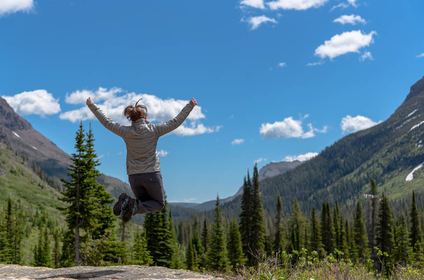 Woman Leaps in Front of Montana Wilderness - 写真・画像