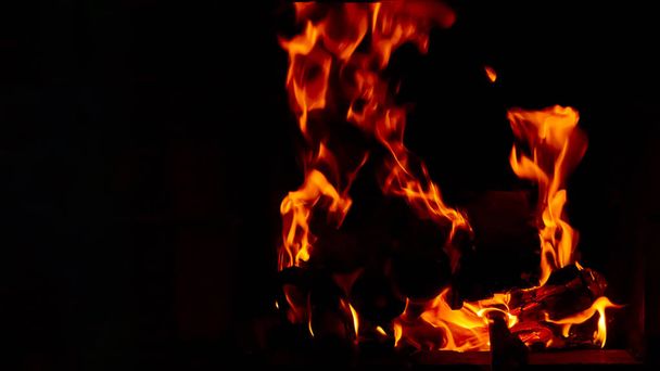 Behang met een felle brand in de vuurkorf. Vlam van vuur. Voorbereiding voor het koken van barbecue, kebab. Hete kolen met verlichting. - Foto, afbeelding