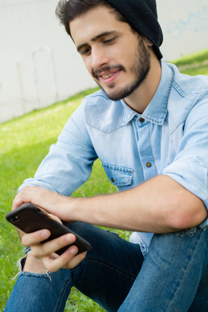 Young man using his phone. Outdoors. - Foto, imagen