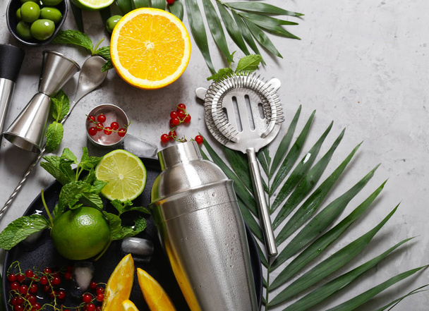 cocktail shaker on the background of fruits and tropical leaves - Photo, Image