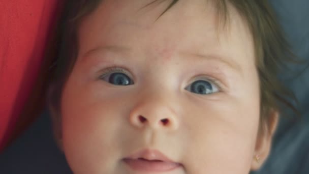 Slow motion of beautiful baby girl looking at the camera - Кадры, видео