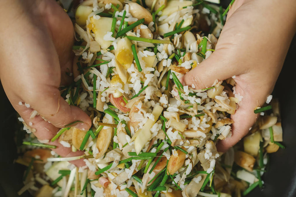 Manos mezclando arroz y verduras
 - Foto, Imagen
