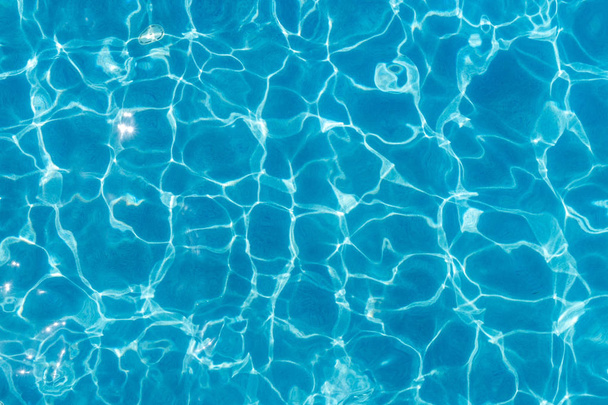 Superfície da piscina com reflexão clara e padrões de ondulação de água
 - Foto, Imagem
