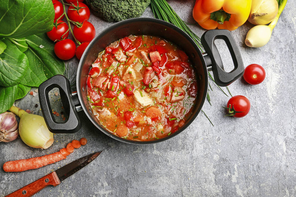 Goulash soup and colorful vegetables on grey stone background.  - Foto, Imagen