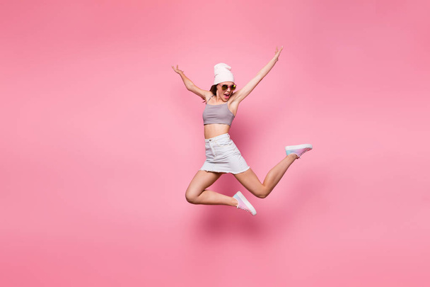 Ful length foto van leuke tiener springen met verhoogde handen schreeuwen dragen brillen brillen geïsoleerd over roze achtergrond - Foto, afbeelding
