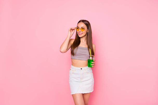 Portrait of cute youth holding plastic cup looking touching yellow specs wearing grey singlet white shorts isolated over pink background - Φωτογραφία, εικόνα