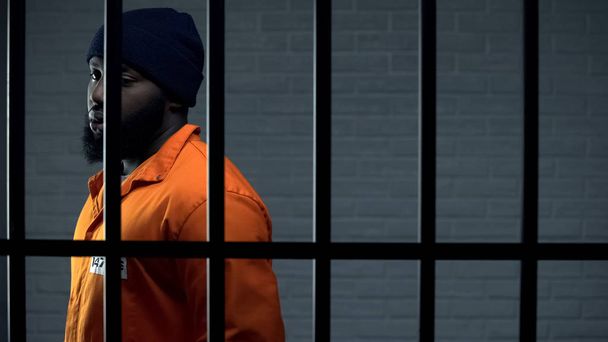 Afro-american criminal in jail cell serving sentence, punishment for kidnapping - Zdjęcie, obraz