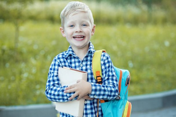 Sırt çantası ve kitapları olan mutlu küçük bir öğrenci. Kavramı - Fotoğraf, Görsel