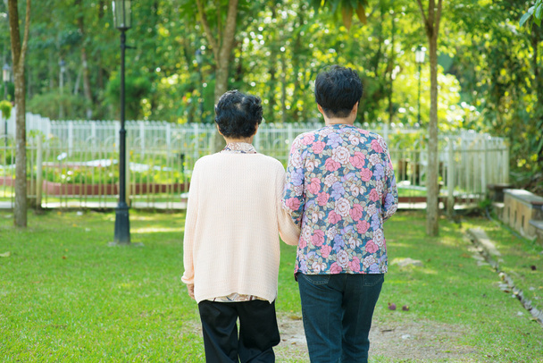 Rear view Asian old mother and senior daughter walking at outdoo - Photo, Image
