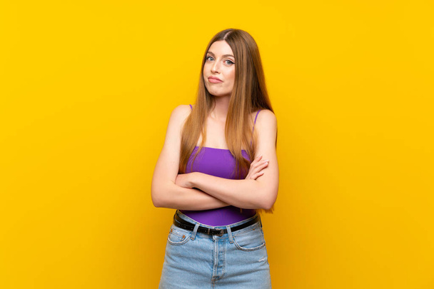 Young woman over isolated yellow background making doubts gesture while lifting the shoulders - Foto, immagini