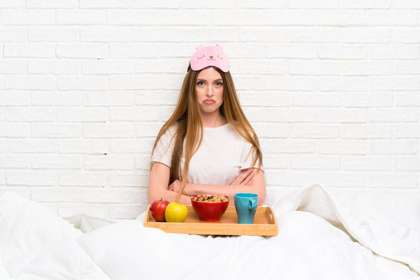 Young woman in dressing gown with breakfast sad - Photo, Image