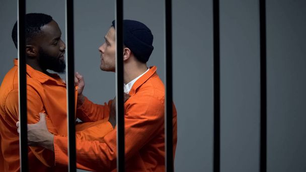 Caucasian prisoner fighting with black inmate, discrimination, jail overcrowding - Zdjęcie, obraz