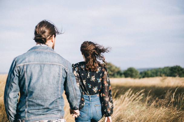 Girlfriend and boyfriend walk in the field. - Фото, зображення