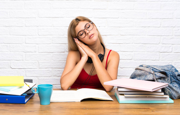 Teenager student girl at indoors making sleep gesture in dorable expression - Foto, immagini