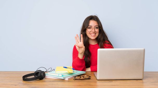 Teenager student girl studying in a table happy and counting three with fingers - Photo, Image