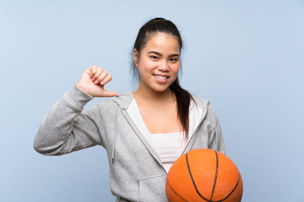 Genç Asyalı kız izole arka plan gurur ve kendini memnun üzerinde basketbol oynuyor - Fotoğraf, Görsel