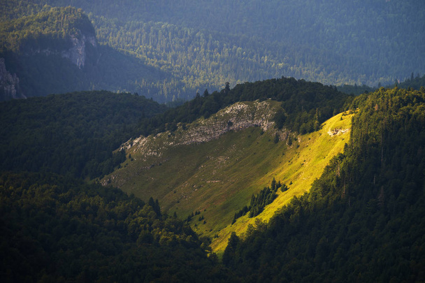 Сонячний промінь на схилі пагорба в горах  - Фото, зображення