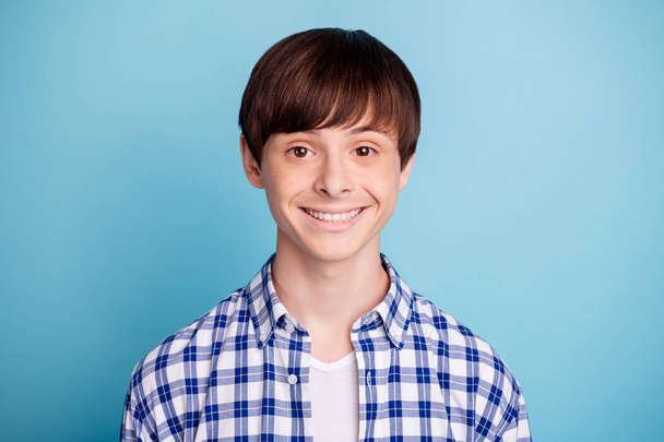 Portrait of charming boy looking wearing checked shirt isolated over blue background - Фото, изображение