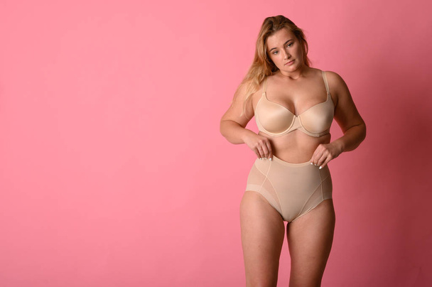 attractive chubby girl in underwear on pink background - Фото, зображення