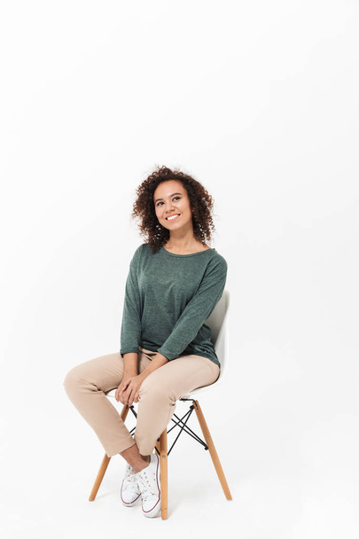 Attractive young african woman sitting on a chair - Fotografie, Obrázek