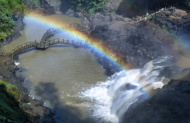 Duplo arco-íris e cachoeira, abaixo está uma ponte sobre o rio para criar vistas deslumbrantes pela manhã na floresta ecológica
 - Foto, Imagem