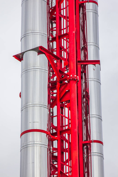 silver metal pipe on a bright red iron frame. external networks on a white background - Foto, Imagem