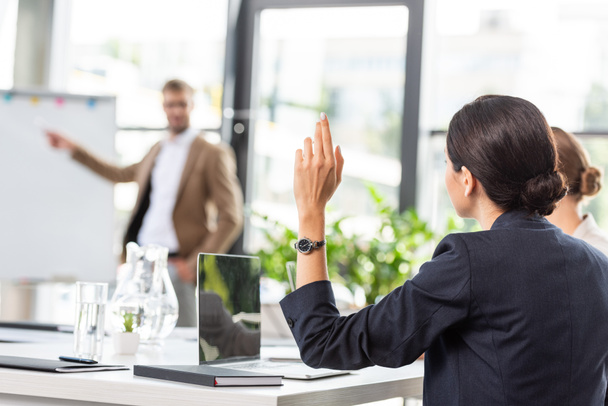 назад взгляд предпринимательницы, поднимающей руку во время конференции в офисе
 - Фото, изображение