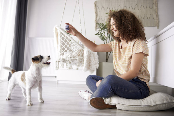 Boldog lány játszik kutyájával otthon  - Fotó, kép