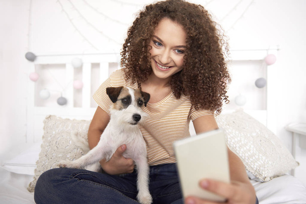 Teenager-Mädchen und ihr Hund machen ein Selfie  - Foto, Bild