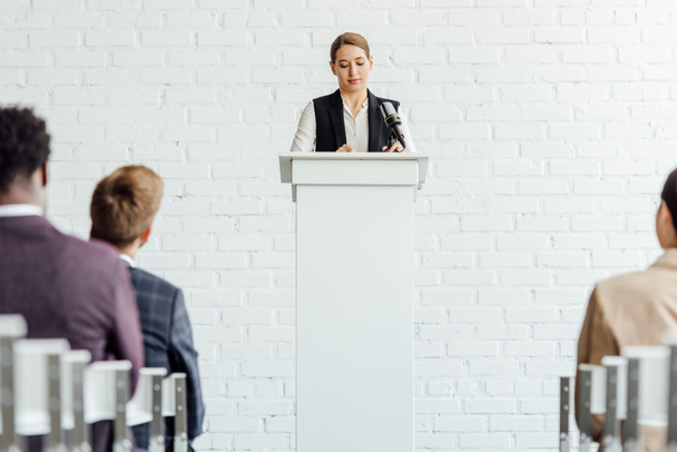 attractive businesswoman standing and talking during conference in conference hall - Foto, Imagem