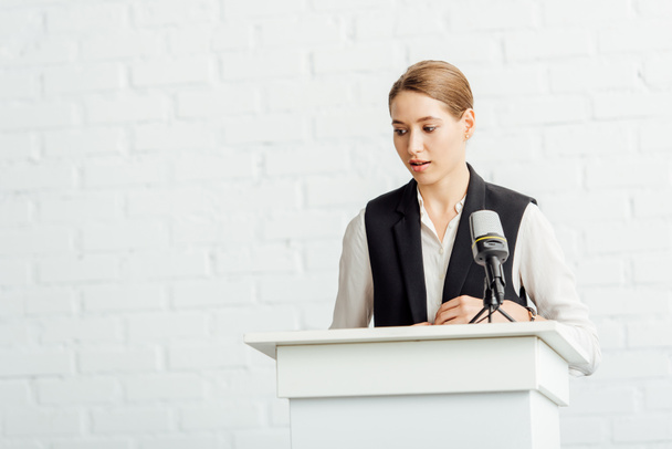 attraente donna d'affari in piedi e parlando durante la conferenza in sala conferenze
 - Foto, immagini