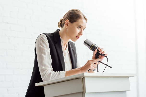 attractive businesswoman standing and talking during conference in conference hall - Foto, imagen