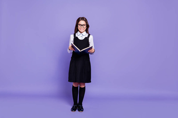 Full length body size view of nice attractive cheerful cheery content diligent wavy-haired pre-teen girl holding in hands reading useful literature isolated over bright vivid shine violet background - Valokuva, kuva