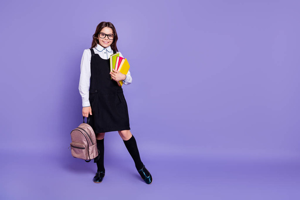 Full length body size view of nice attractive cheerful cheery diligent wavy-haired pre-teen girl carrying holding in hands academic literature isolated over bright vivid shine violet background - Fotó, kép