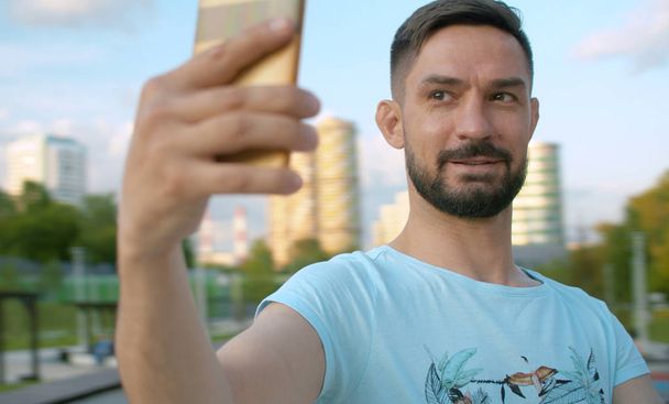 Portrait of the smiling man shooting selfie - Photo, Image