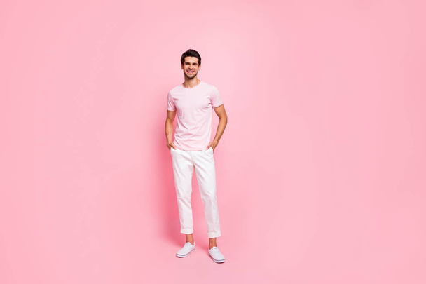 Full length body size view portrait of his he nice attractive lovely cheerful cheery content guy posing holding hands in pockets isolated over pink pastel background - Fotó, kép
