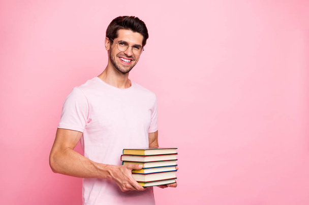 Portrait of his he nice attractive content confident diligent cheerful cheery glad positive intelligent guy holding in hands carrying book library isolated over pink pastel background - Fotó, kép