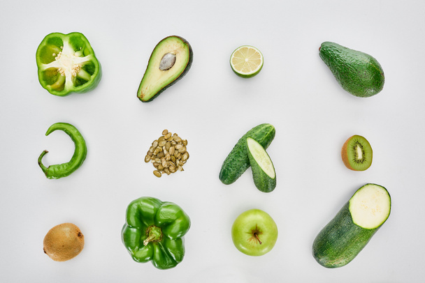 top view of apple, avocados, cucumbers, lime, peppers, pumpkin seeds and zucchini - Fotografie, Obrázek