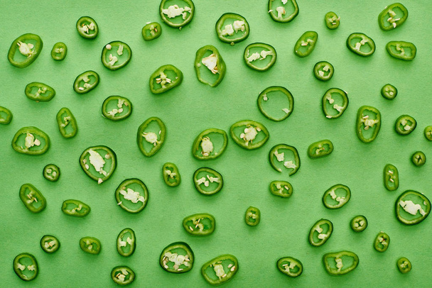 top view of sliced and fresh peppers on green background  - Foto, Imagem